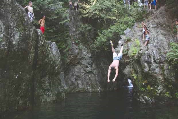 Cliff jumping at Lynn Valley Canyon. An experienced jumper dives into the pond.