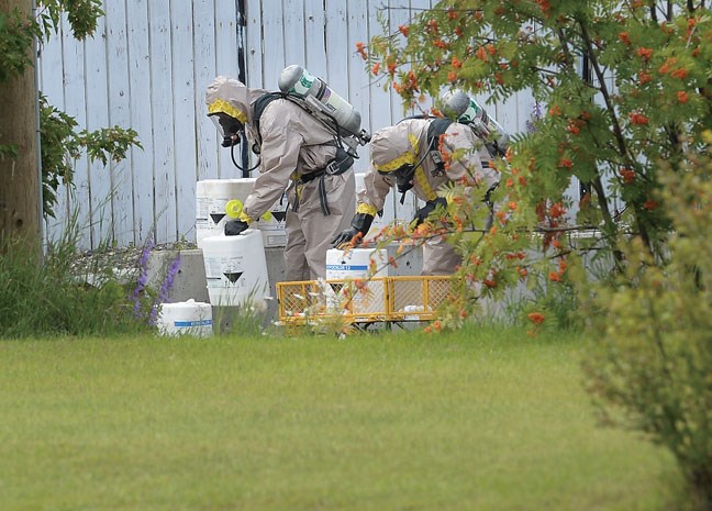 City of Prince George Fire/Rescue Service hazmat team heads in to deal with containers of hazerdous materials found in an alley of of 13th Avenue behind Central Street Tuesday. Citizen photo by Brent Braaten July 19 2016