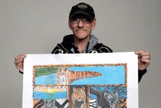 Artist Ray Fortin shows off his painting of the letter T for the Alphabet Project