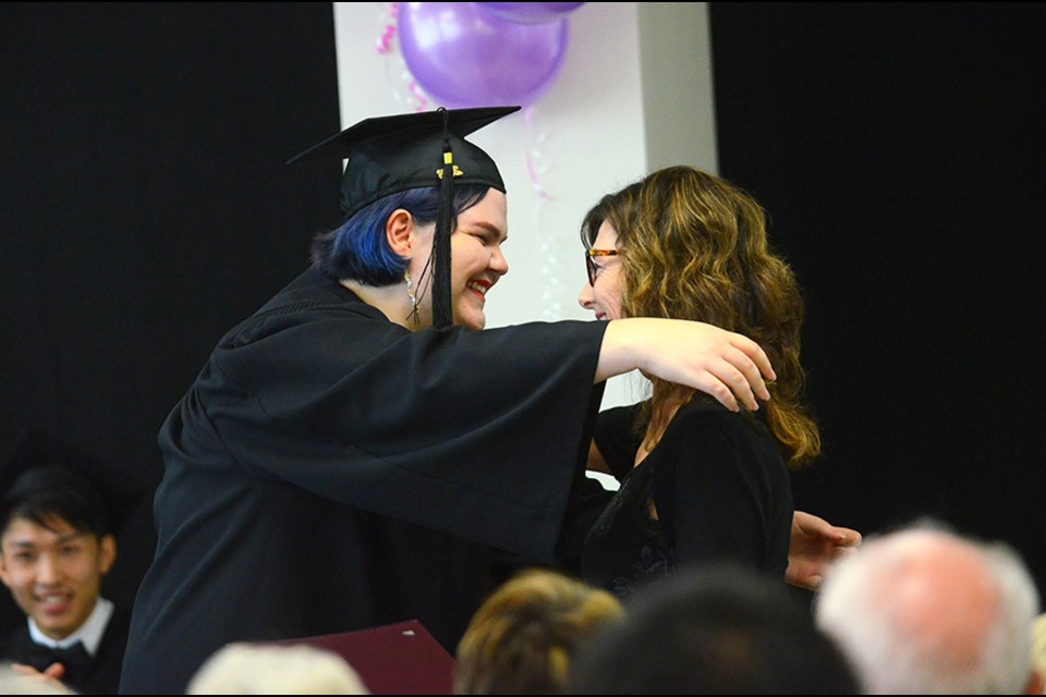 POWER Alternate Secondary School grad Kat Smith and counsellor Stephanie Saville share a hug during a convocation ceremony at the alternate education school at Columbia Square shopping centre this year.
