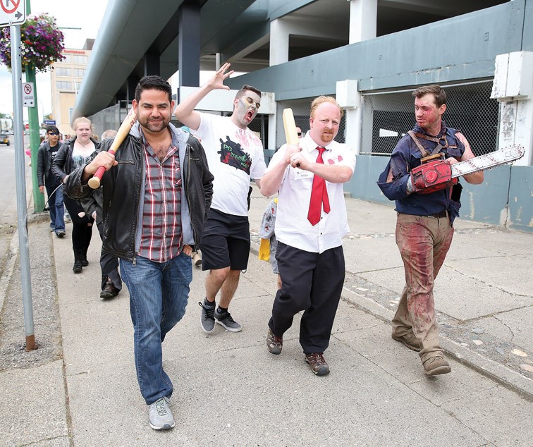 From left, Juan Pareja from the television show Walking Dead, Tyler Martin as Shaun from Shaun of the Dead, and Ben Gibson as Ash Williams from Evil Dead lead a parade of zombies through downtown Prince George on Saturday as part of the 2nd Annual Prince George Zombie Fest. Citizen Photo by James Doyle July 23, 2016