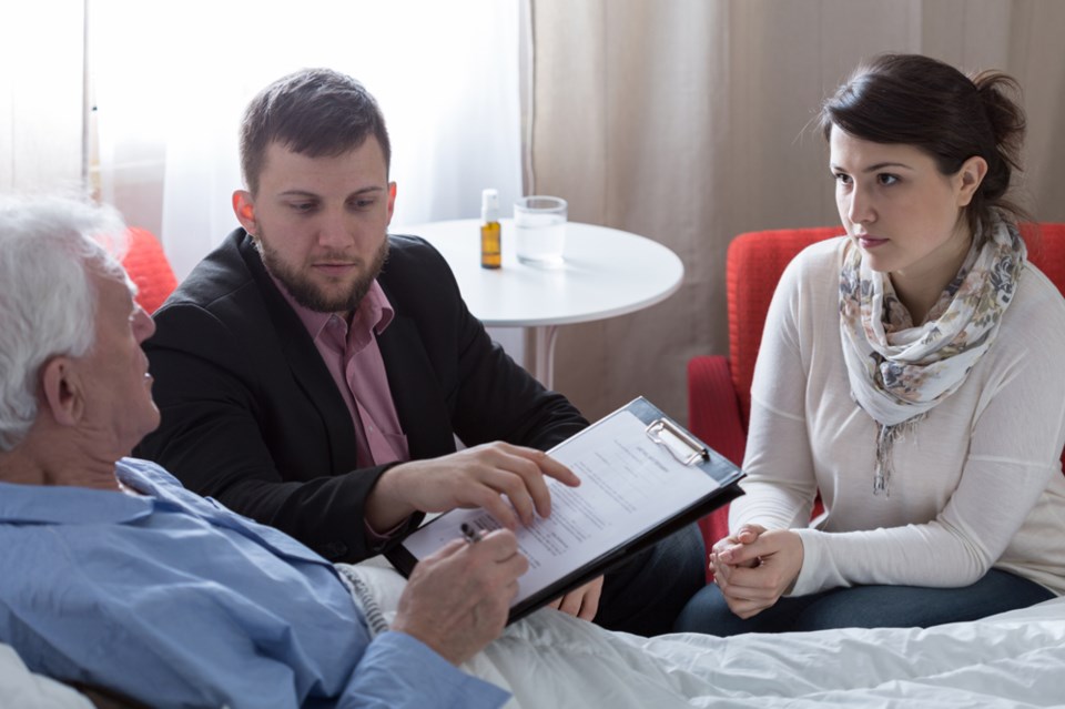 senior in bed signing documents