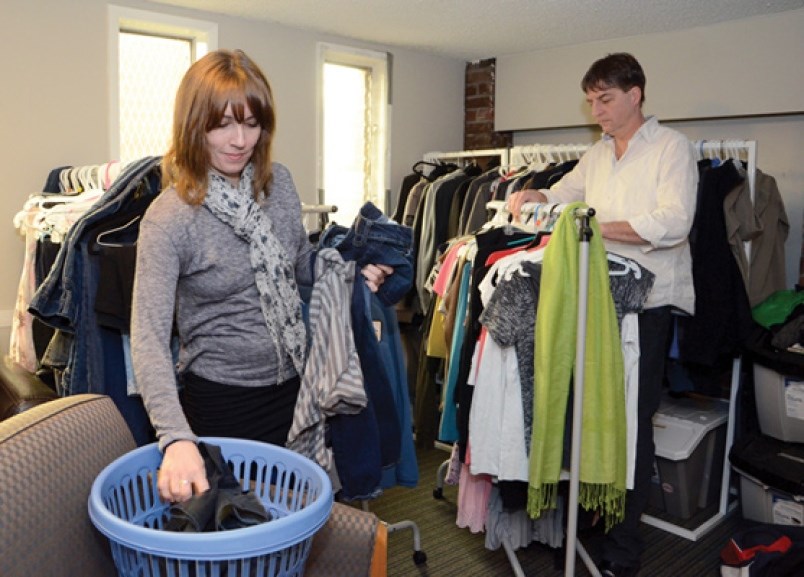 Natalie Labelle, safe house supervisor, and Paul Butler check the supply of donated clothing for tee