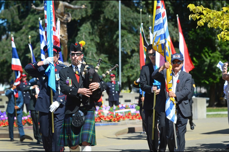 A piper leads a colour party at a Koreans War Veterans Day ceremony at the Ambassador of Peace Korean War Memorial in Burnaby's Central Park Wednesday.