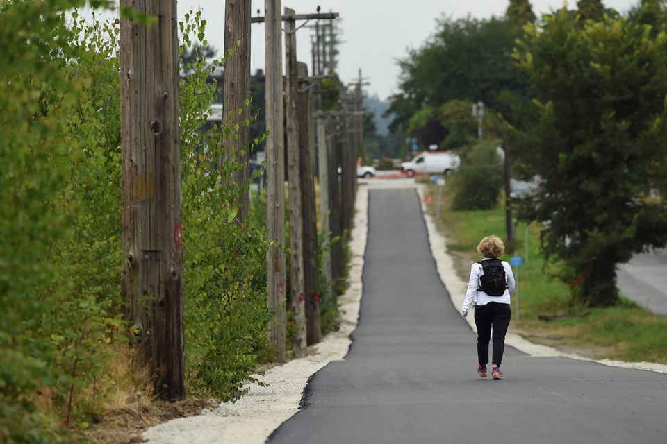 A temporary asphalt path is in the process of being put down along Arbutus corridor to encourage more people to use the route in anticipation of this fall’s visioning process for the land. Photo Dan Toulgoet