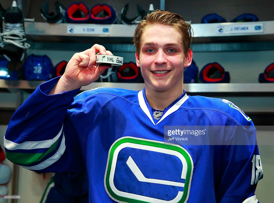 Jake Virtanen holds up the puck from his first NHL goal