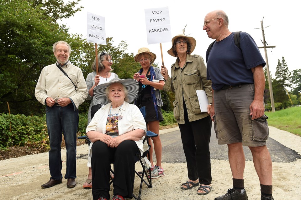 Mark Battersby (left) and a handful of other protesters, including Diana Davidson (centre) demonstrated against the use of asphalt on Arbutus Greenway earlier this week. photo Dan Toulgoet