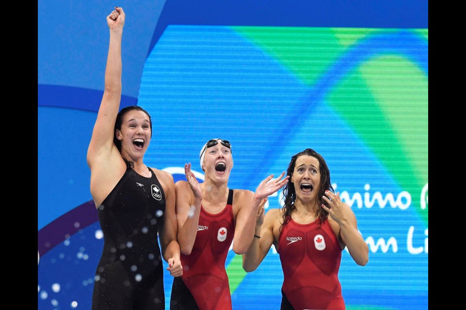The Canadian women's 4x100-metre freestyle relay team Chantal Van Landeghem, left to right, Taylor Ruck, Sandrine Manville and Penny Oleksiak (not shown), celebrate their bronze medal finish at the 2016 Summer Olympics, in Rio de Janeiro, Brazil, Saturday, Aug. 6, 2016. THE CANADIAN PRESS/Frank Gunn