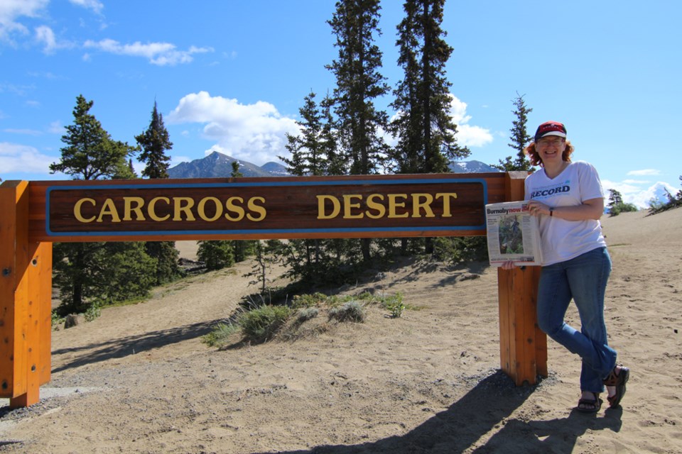 Julie MacLellan, the Burnaby NOW’s assistant editor, poses with her hometown newspaper at the Carcross Desert, Yukon, during a family trip north in May., the Burnaby NOW’s assistant editor, poses with her hometown newspaper at the Carcross Desert, Yukon, during a family trip north in May.