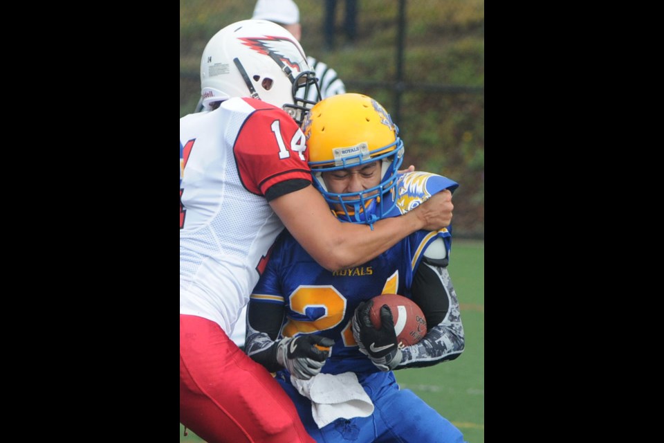 Handsworth running back Rokin Wong gets wrapped up by a Carson Graham defender during the 25th annual Buchanan Bowl played Saturday at Confederation Field. Carson won 62-36 in the highest scoring game in Buchanan Bowl history.