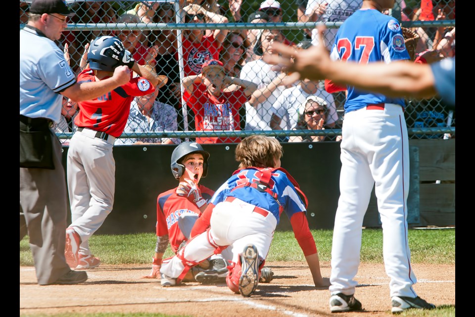Hastings All-Stars’ Antonio Cusati looks shocked at being called out at the plate, seconds after teammate Matteo Ripoli, No. 1, scored what would be the game’s only run in Saturday’s Canadian Little League final at Hastings Community Park in Vancouver.
