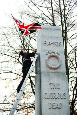 North Vancouver firefighter Mark Hallaway places a flag on the cenotaph at Victory Park prior to the Remembrance Day ceremony.