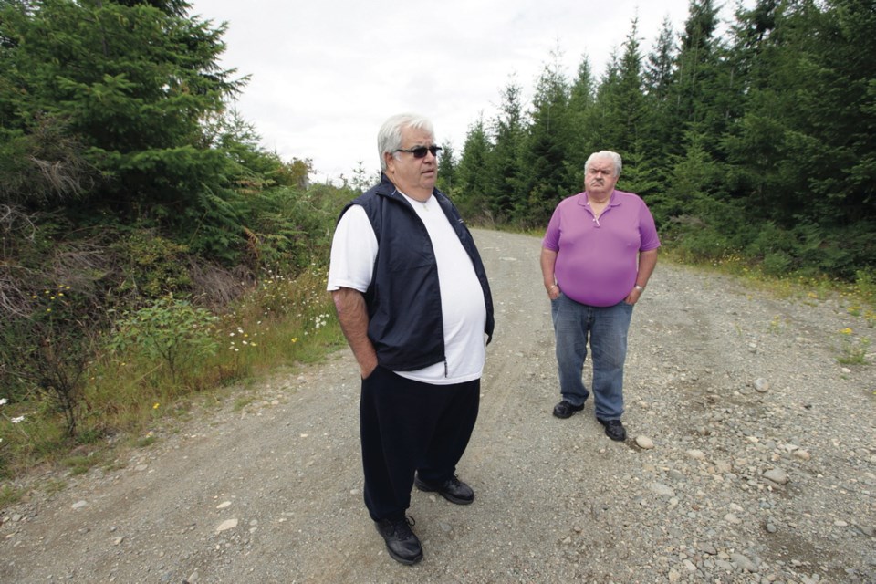 Tlowitsis First Nation Coun. Thomas Smith, left, and his brother, John, who is chief, stand on property the Tlowitsis have agreed to purchase: 630 acres of private forest land south of Campbell River. The plan calls for the Tlowitsis to pay $3.5 million for the property and then transfer the land to the Crown.
