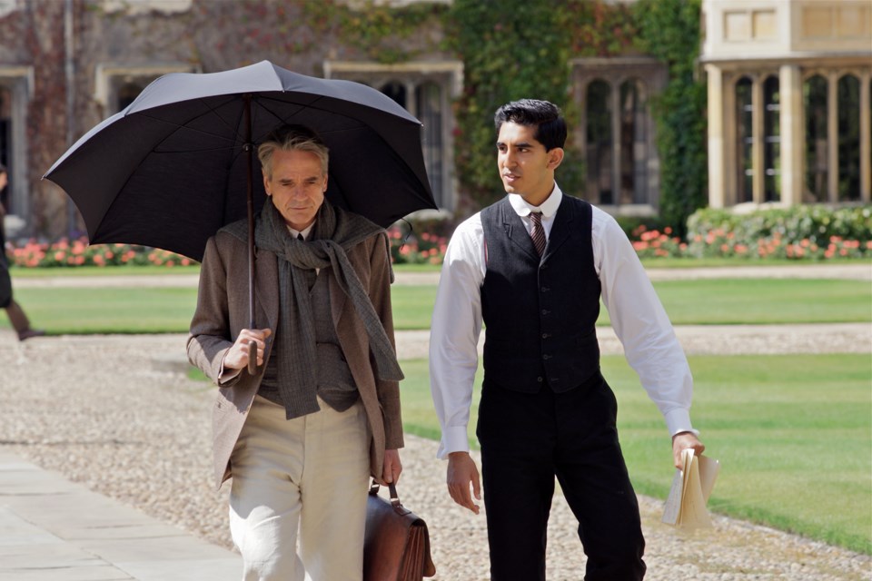 G.H. Hardy (Jeremy Irons) and Srinivasa Ramanujan (Dev Patel) walk through the Quad at Trinity College, Cambridge in Matthew Brown’s The Man Who Knew Infinity.