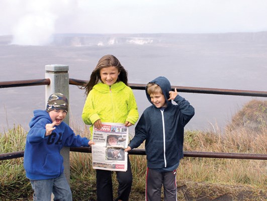 Spencer Gray, Anna Smolik and Magnus Smolik take the paper to Kilauea Volcano, an active crater with rising steam in Hawaii.