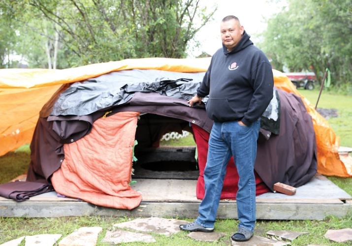 Jason Gillis stands in front of the sweat lodge he has built in his backyard. Gillis built the sweat lodge to help deal with his post-traumatic stress disorder (PTSD) and plans on offering it to other first responders as well.