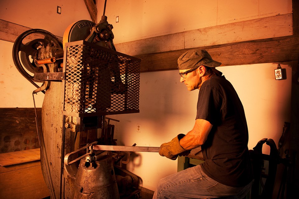 Squamish blacksmith Eric Gindlesperger runs a 1947 100 pound power hammer at his downtown shop.