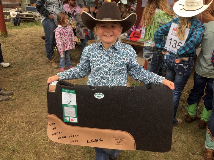 Nevada Jones, 8, shows off her new saddle pad which she won when she was the high point champion in the junior division at the Little Britches Rodeo at Nukko Lake rodeo grounds last weekend.