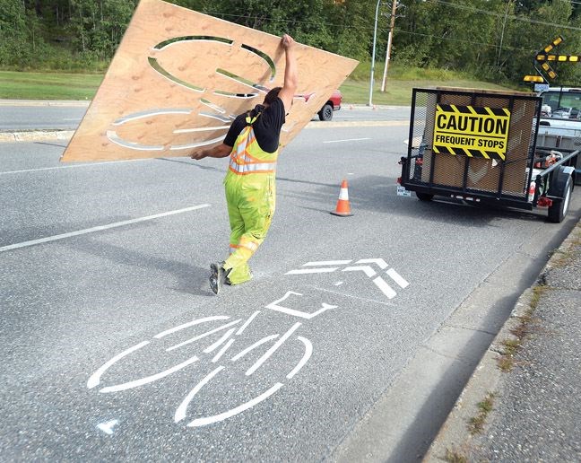 Crews from Yellowhead Pavement Marking paint the new bike markings on Massey Drive Friday morning. This symbol refers to shared use lanes.