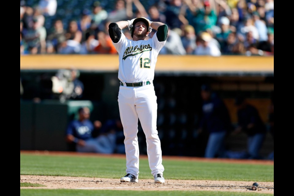 Oakland Athletics' Max Muncy (12) reacts after he strikes out looking to end the game in a 3-2 loss to the Seattle Mariners on Sunday at the Oakland Coliseum in Oakland, Calif.