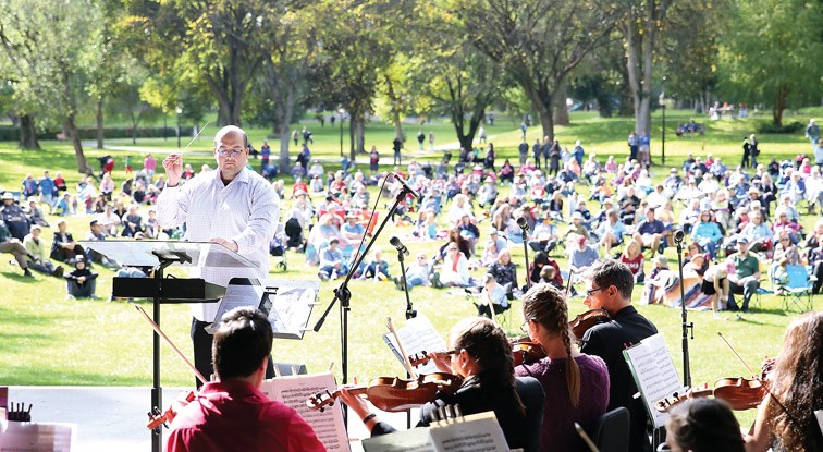 Conductor José Delgado-Guevara leads the Prince George Symphony Orchestra on Sunday at Lheidli T'enneh Memorial Park. Roughly 400 attendees were treated to the classical music of Gilbert and Sullivan the annual Pops in the Park event. Citizen Photo by James Doyle September 11, 2016