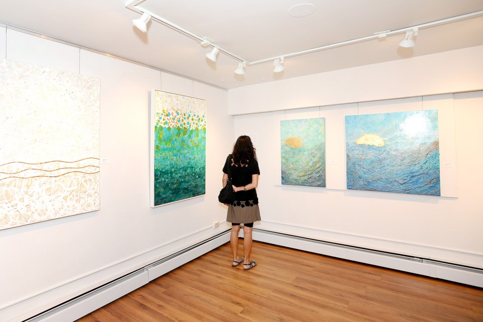 A visitor examines the work at the Diffusion opening reception.