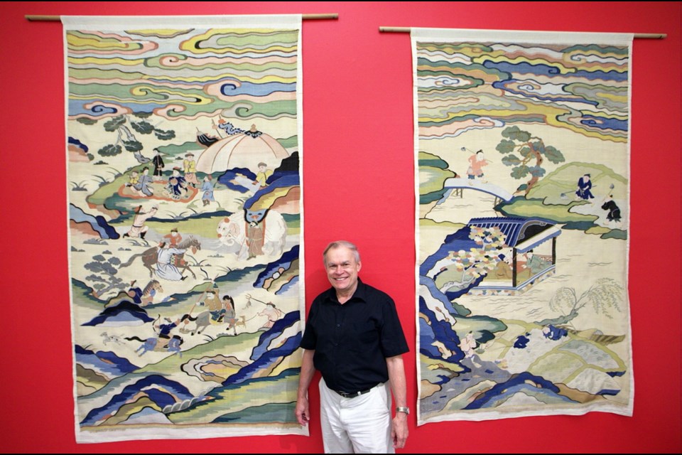 Asian-arts curator Barry Till with cut silk tapestries.