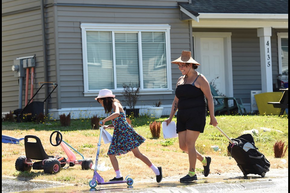 Deanne Michelle and her niece Raina Grant deliver notices to doorsteps on the Musqueam reserve in southwest Vancouver. Photo Dan Toulgoet