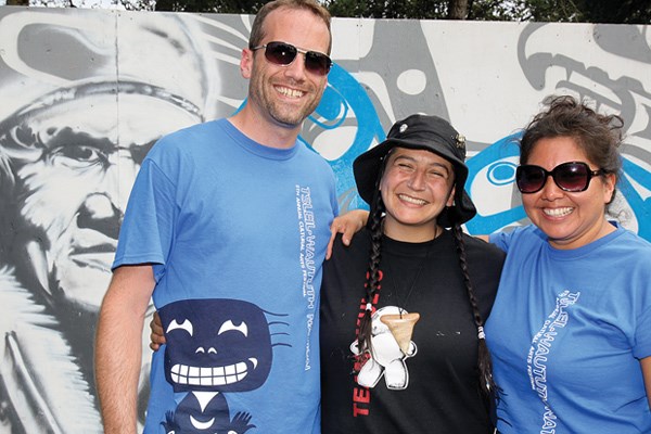 Co-organizers Andrew Van Eden and Charlene Aleck flank Larissa Healey in front of mural created by Healey and Corey Bullpit.