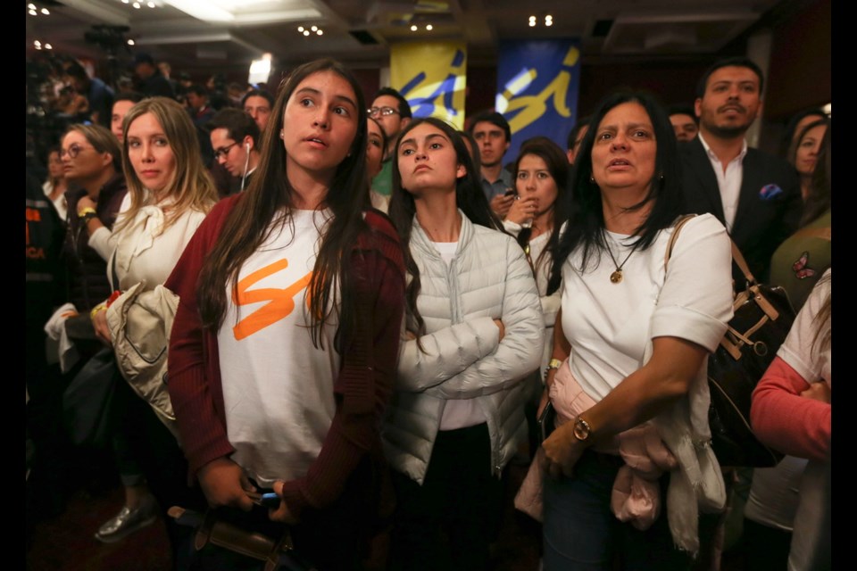 Supporters of the peace deal signed between the Colombian government and rebels of the Revolutionary Armed Forces of Colombia, FARC, listen to results of a referendum to decide whether or not to support the deal at the "yes" vote headquarters in Bogota, Colombia, Sunday. Colombia's President Juan Manuel Santos recognized the referendum defeat.