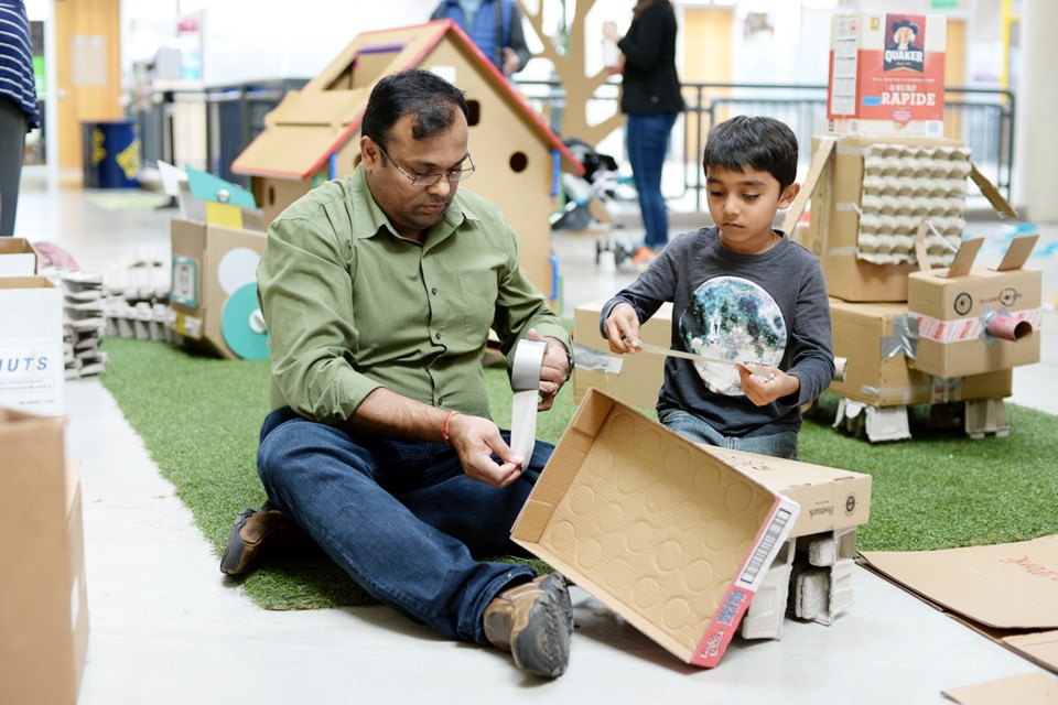 Six-year-old Neil Thakkar and Veeral Thakkar work on their cardboard creation.
