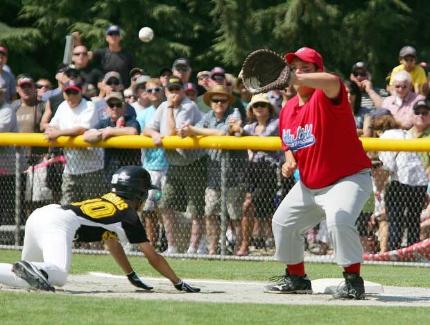 Ken Dubois of Langley dives back to first as Nikko Barr of Valey Field Que tries to make the out during thje Little League Final on Saturday.