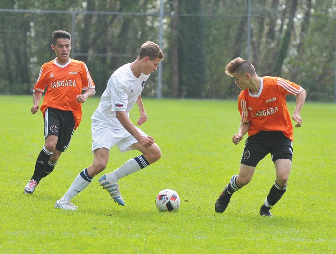 Capilano University's Keith Jackson scoots by a pair of defenders during a recent PacWest game against Langara. photo by Paul McGrath, North Shore News