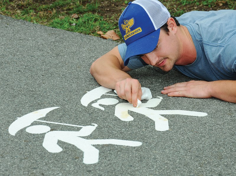 City of North Vancouver parks department worker Jeff Lavis tidies up one of the whimsical drawings from the Whatever the Weather permanent art installation on the Green Necklace trail around central Lonsdale. The display was the brainchild of Vancouver artist Mia Weinberg. photo by Cindy Goodman, North Shore News