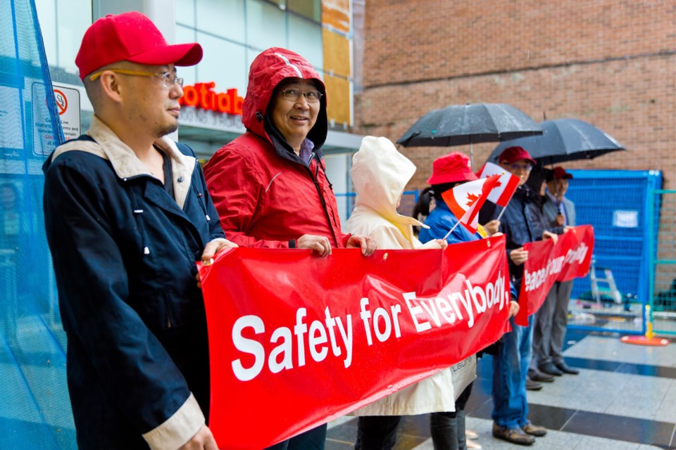 Activists outside the Brighouse Canada Line Station call for increased safety. They are concerned the Chinese community in Richmond is being targeted.