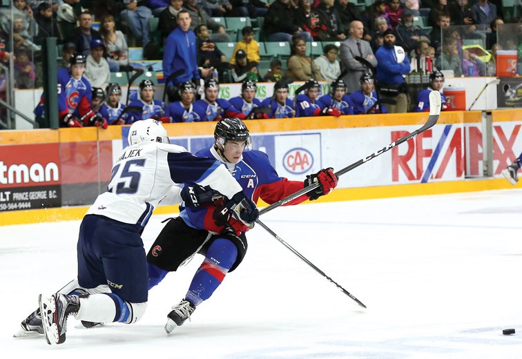 Cougars left winger Colby McAuley cuts around Saskatoon Blades defenceman Libor Hajek during their WHL game Saturday at CN Centre. The Cougars hung on for a 2-1 victory to improve their league-leading record to 11-2-1-0.