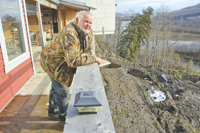 Old Fort resident Darrell Williams looks over his home's balcony onto a landslide he believes is being caused by pile driving and blasting work at the Site C dam site, roughly two kilometres upstream.