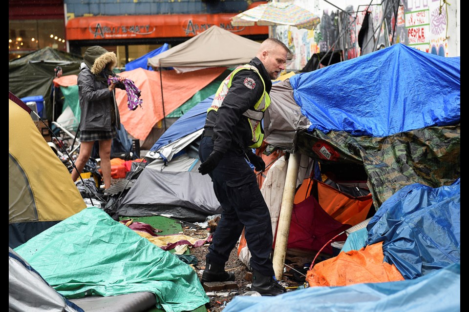 The Vancouver Fire Department’s Fire Prevention Division Captain Marcus von Minder checks tents for campers. Photo Dan Toulgoet