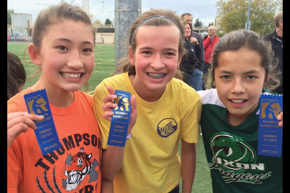 All three will eventually receive first place ribbons after (left to right) Lianna Holz, Lexy Shury and Teagan Ng decided to share top honours in their final race at the annual Richmond Elementary Schools Cross-Country Fun Run.