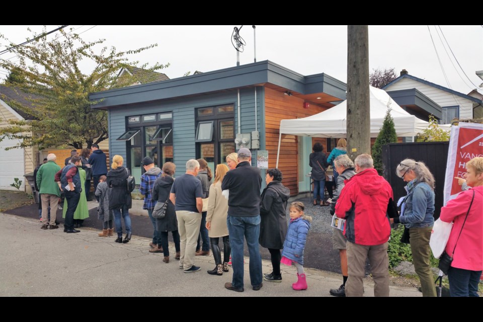 Attendees at this year's Vancouver Heritage Foundation’s laneway house tour lined up to view a small single-level house. Photo Michael Geller