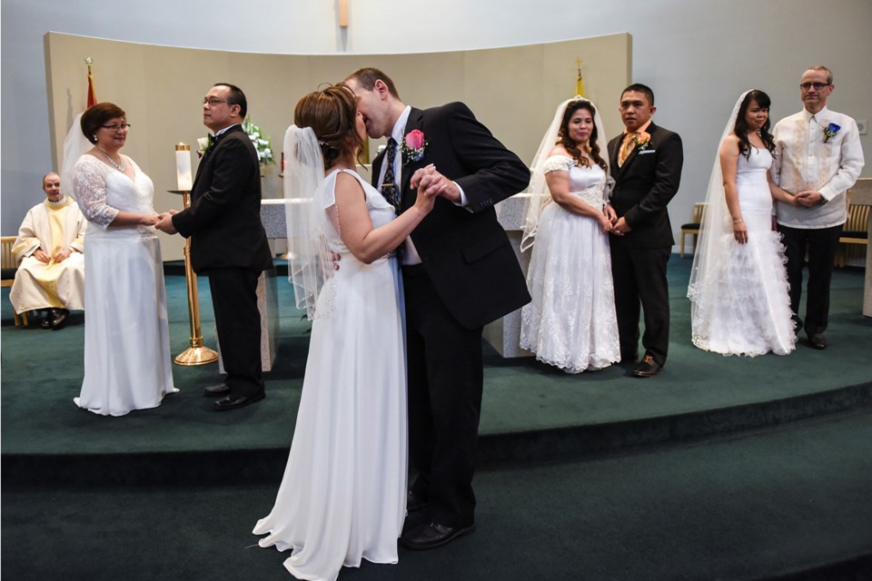 Iona and Kelly Matiowsky waited their turn to seal the deal during a mass wedding ceremony at St. Mary’s Parish. Photograph by: Rebecca Blissett