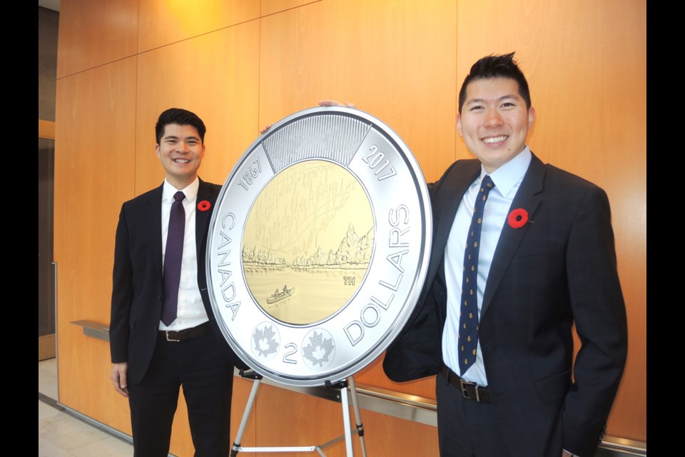 Richmond’s Dr. Timothy Hsia, right, shows off his winning 2017 toonie design at city hall with his brother, Stephen, who was also a finalist in the Royal Canadian Mint’s competition to mark the country’s 150th anniversary next year. Timothy credited his brother for helping him win the national contest.