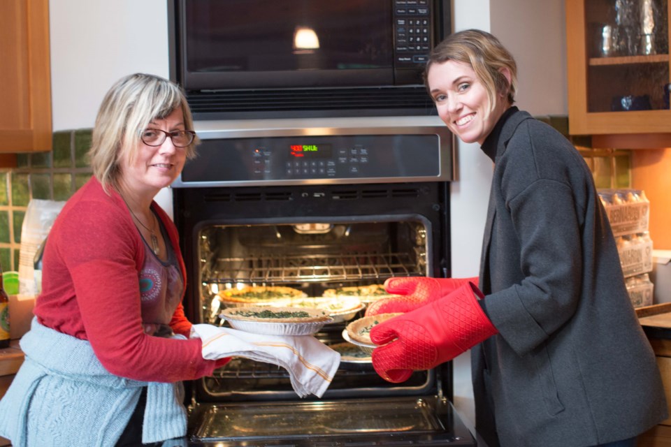 Leah May Walker of Bowen Agricultural Alliance (left) and Michelle Catherine Nelson, author of The Urban Homesteading Cookbook (right) pull fragrant walnut, yam, blue cheese and seaweed quiches from the oven, foraged and prepared by the group of Bowen Islanders participating in the workshop and long table lunch last Saturday.