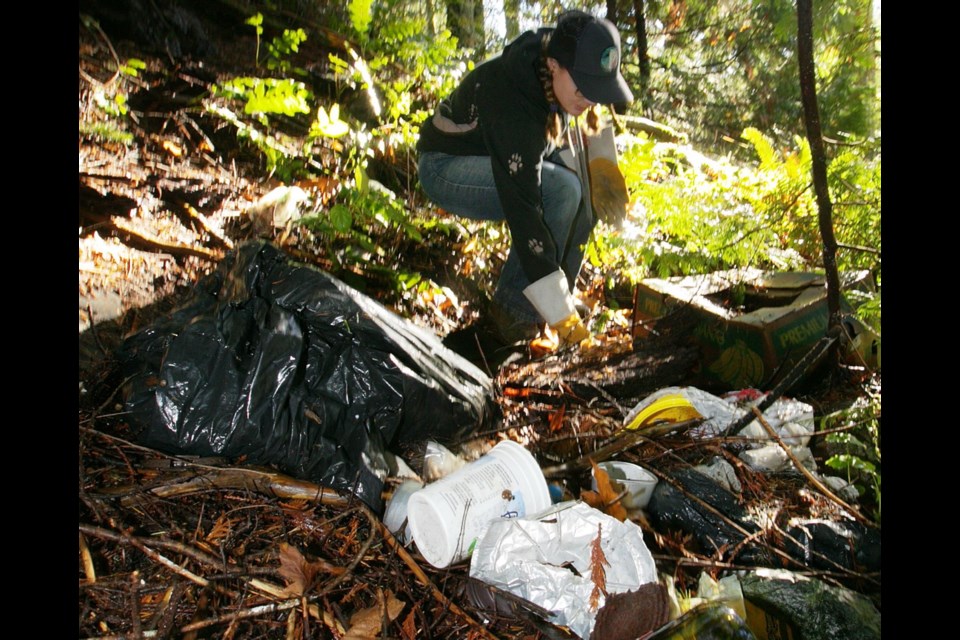 Kathleen Woodruff picks up garbage dumped near Goldstream Provincial Park. Some dread the effects on the ecosystem and the potential impact on salmon and the food chain.