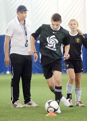 Technical director Claudio Bartolomeo works with senior players Tristan Jahnke-Carrier and Tessa Cleveland.