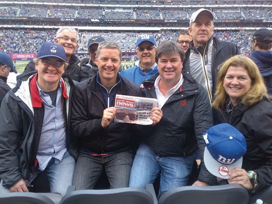 John O'Neill (holding the paper) celebrates his 50th birthday at a New York Giants home game with his six brothers and two in-laws.