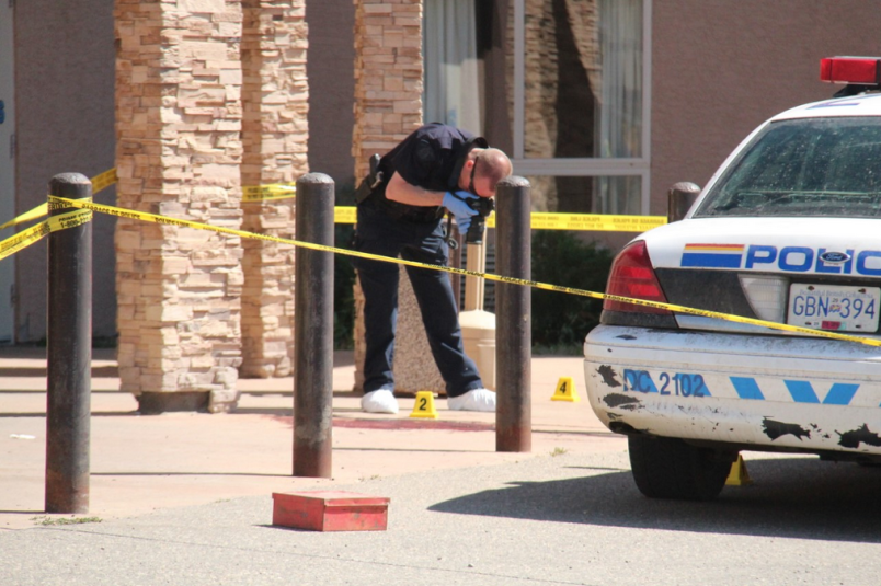 An RCMP member photographs the scene where James McIntyre was shot by police July 16, 2015.