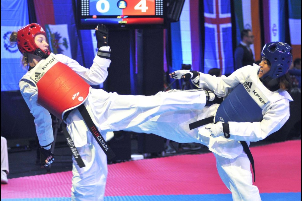 Burnaby’s Josipa Kafadar, in red, applies a left foot kick to opponent Bhawana Lam of Nepal during Friday’s opening round action of the female 52kg division.