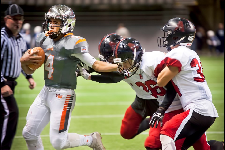 New Westminster quarterback Kinsale Philip, at right, out-races a trio of Abbotsford tacklers to the sidelines during Saturday’s 44-35 victory, propelling the Hyacks into this weekend’s semifinals at BC Place against Notre Dame.