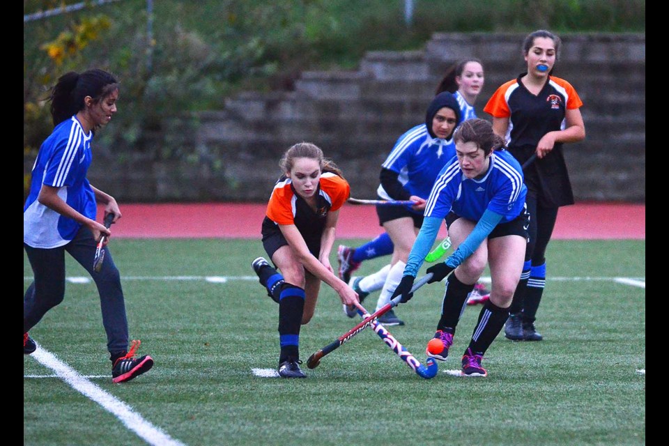 New Westminster's Ella Fetherstonhaugh drives the ball forward while facing pressure from Moscrop checkers during last week's Burnaby-New West field hockey final.